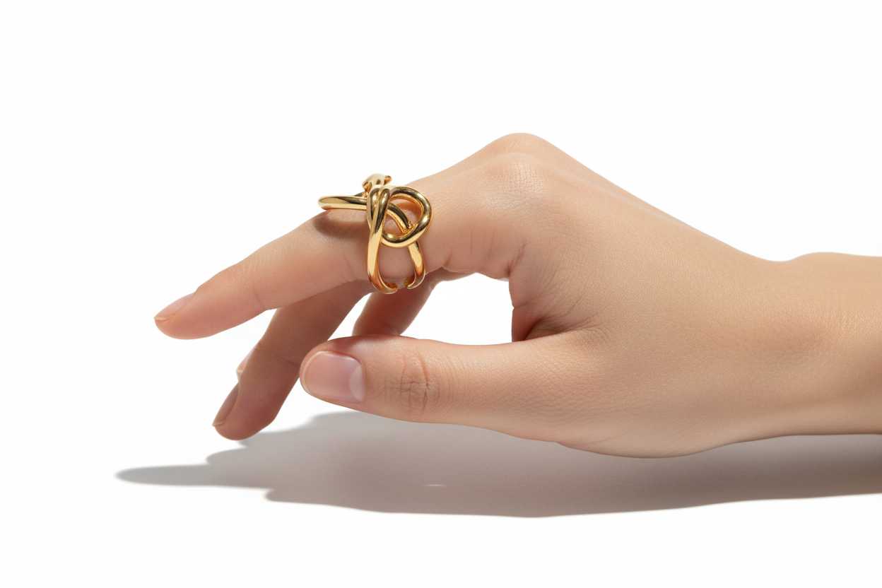 Hand wearing a gold ring on a white background
