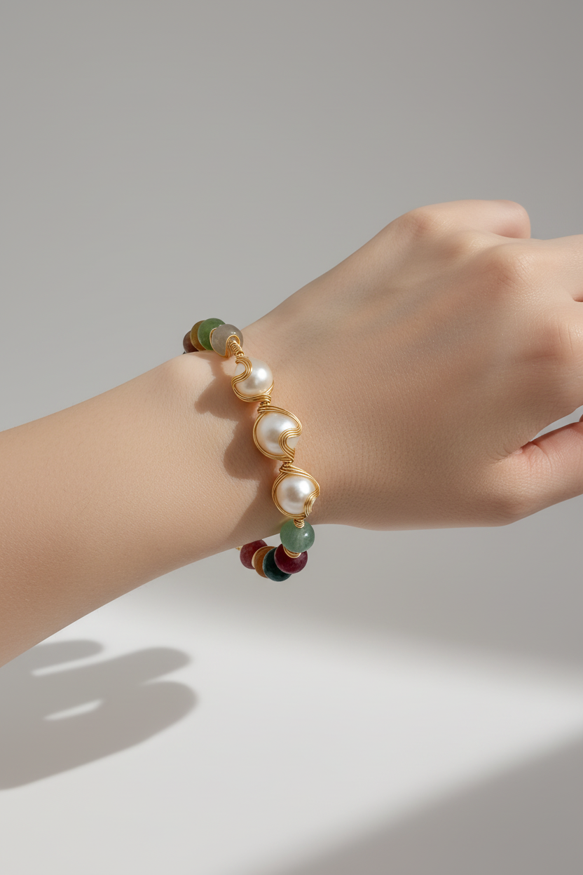 Hand wearing a pearl bracelet on a neutral background
