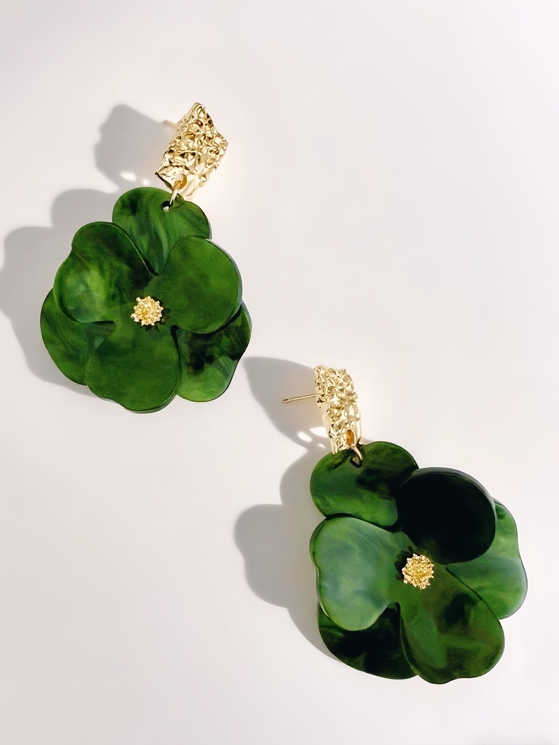 Green floral earrings with gold accents on a white background