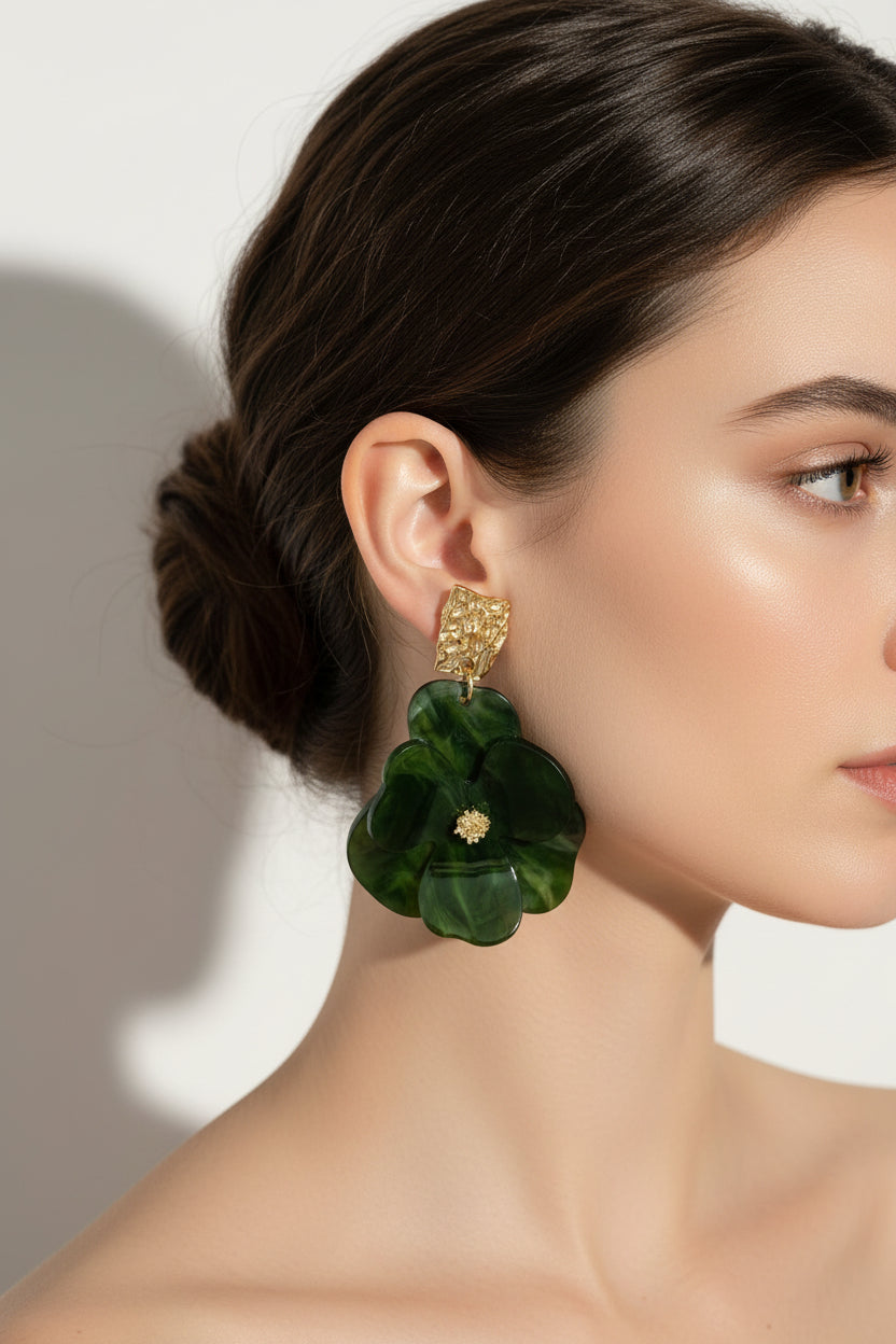 Green floral earrings with gold accents on a light gray background